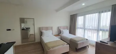 a hotel room with two beds and a window at Petra Port Hotel in Tuzla