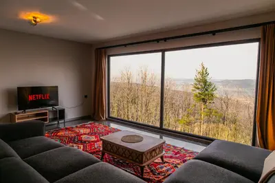 a living room with a couch and a large window at PANA Sapanca Lake View in Sapanca
