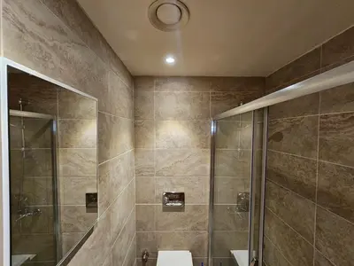 a bathroom with a shower and a toilet and a sink at Taksim Perfect Residence, 3 bedrooms, pool, sauna, gym in Istanbul