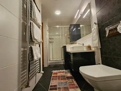 a bathroom with a toilet and a sink and a shower at Taksim Perfect Residence, 3 bedrooms, pool, sauna, gym in Istanbul