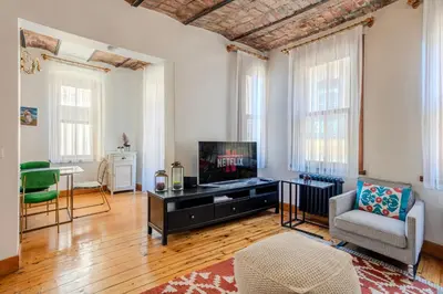 a living room with a television and a couch and a table at Historic Spacious Galata Apartment in Istanbul
