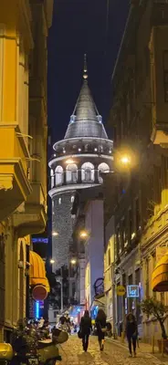 a building with a tower on a street at night at Historic Spacious Galata Apartment in Istanbul
