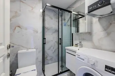 a bathroom with a shower and a washer and dryer at Cozy New Penthouse 1BD Nisantasi Terrace Gem! #334 in Istanbul