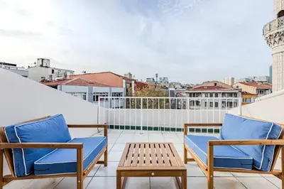 a patio with two chairs and a table on a balcony at Cozy New Penthouse 1BD Nisantasi Terrace Gem! #334 in Istanbul