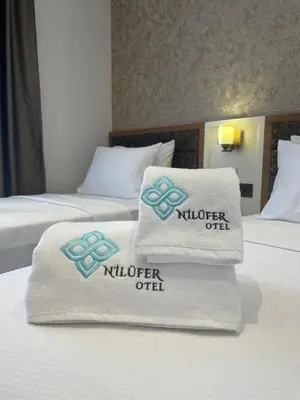 two beds in a hotel room with towels on them at By Otel Nilüfer in Bursa
