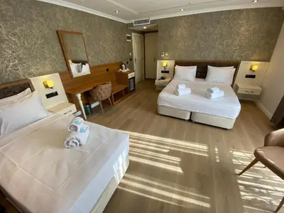 a hotel room with two beds and a desk at By Otel Nilüfer in Bursa