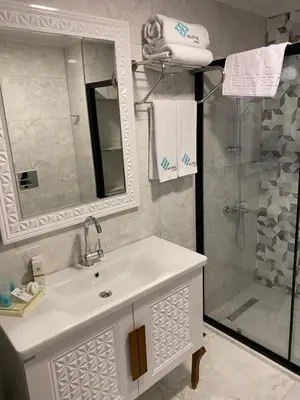 a bathroom with a white sink and a shower at By Otel Nilüfer in Bursa