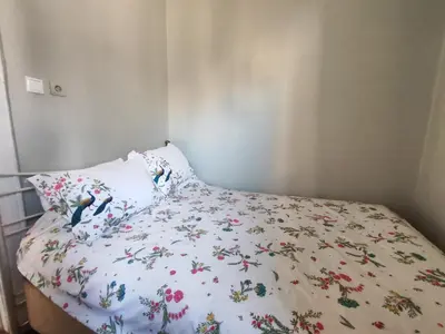 a bed with a floral bedspread and a pillow at Sweet Home in Istanbul