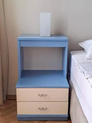 a blue night stand next to a bed at Spacious and Bright Apartment - Dirim House in Istanbul