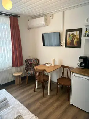 a room with a table and chairs and a tv at Yellowhouse Room 5 in Istanbul