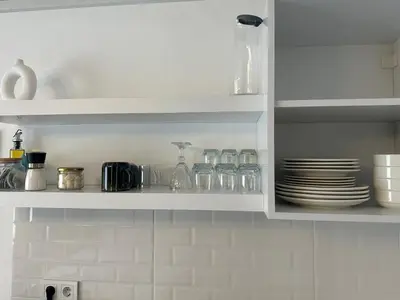 a kitchen shelf with plates and glasses on it at Yellowhouse Room 5 in Istanbul