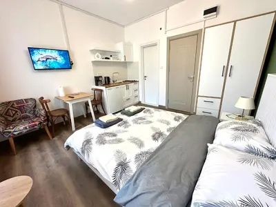 a bedroom with a bed and a table and a kitchen at Yellowhouse Room 3 in Istanbul