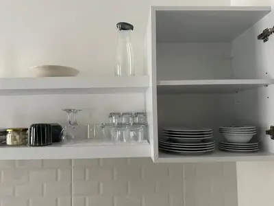 a white cabinet with plates and glasses and a vase at Yellowhouse Room 2 in Istanbul