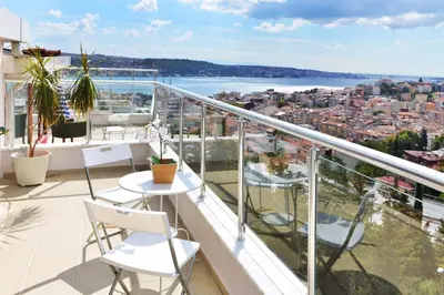 a balcony with white chairs and a view of the water at Bude Ortaköy in Istanbul