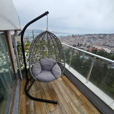 a swing on a balcony with a view of a city at Bude Ortaköy in Istanbul