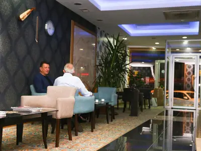 two men sitting at a table in a restaurant at Helenapolis OTEL in Yalova