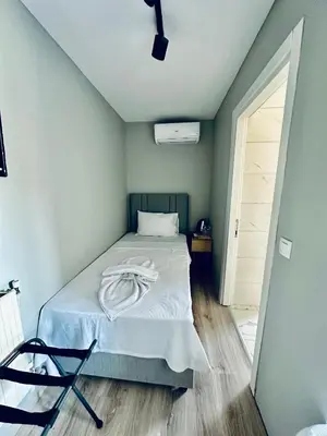 a bedroom with a bed with a white blanket on it at The Hera Gold Hotel in Istanbul