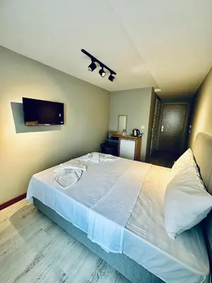 a bedroom with a large white bed and a flat screen tv at The Hera Gold Hotel in Istanbul