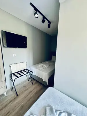 a bedroom with two beds and a flat screen tv at The Hera Gold Hotel in Istanbul