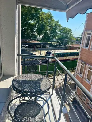 a table and chairs on a balcony with a train at Hisar Çeşme Hotel in Istanbul