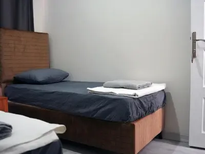 two beds in a room with a bed with towels on it at Mimen Hostel in Istanbul