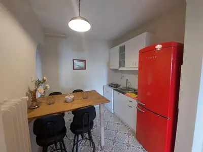 a kitchen with a table and a red refrigerator at Stone Garden Apartment in the Heart of the City in Istanbul