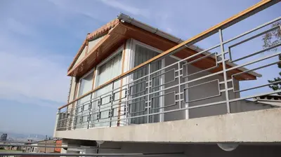 a building with glass windows on the side of it at Cozy Duplex Next to Green Masjid in Yıldırım