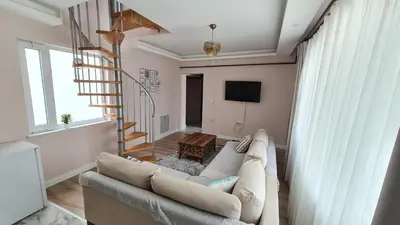 a living room with a couch and a staircase at Cozy Duplex Next to Green Masjid in Yıldırım