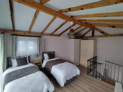 two beds in a room with wooden ceilings at Cozy Duplex Next to Green Masjid in Yıldırım