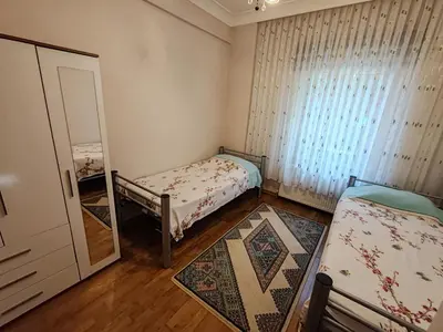 a small bedroom with two beds and a mirror at Garden Floor Flat in a Beachfront Complex with a Pool in Gümüşyaka