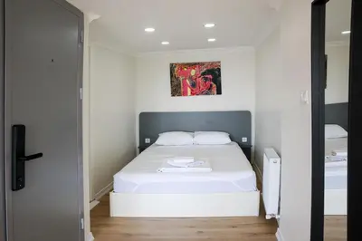 a small bedroom with a bed and a painting on the wall at Beans House Suite 8-26 in Istanbul
