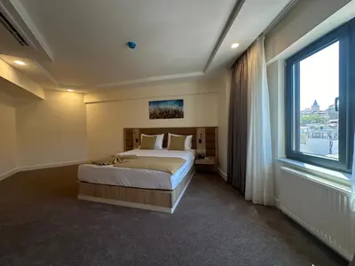 a bedroom with a bed and a large window at Roys Hotel & Suites in Istanbul