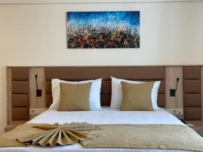 a bedroom with a bed with a painting on the wall at Roys Hotel & Suites in Istanbul