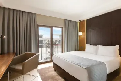 a hotel room with a bed and a desk and a window at Ramada by Wyndham Istanbul Florya in Istanbul