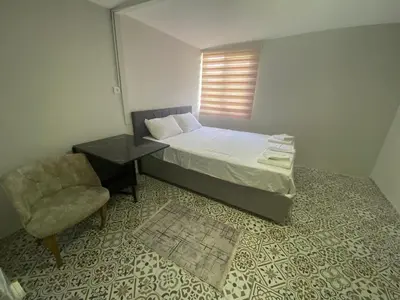 a bedroom with a bed and a chair and a window at The Red Tent Loft Suites in Istanbul