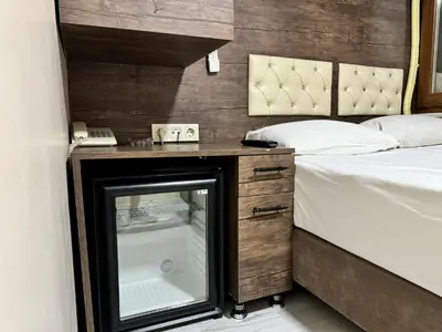 a bedroom with a bed and a desk with a window at Hotel Visa in Istanbul