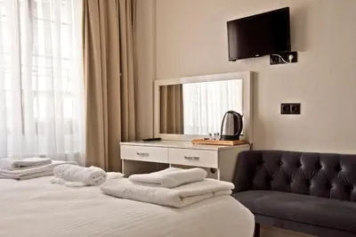 a hotel room with a bed with a couch and a mirror at Yakut Hotel in Istanbul