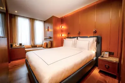 a bedroom with a large white bed with wooden walls at Sura Concept Hotel in Istanbul