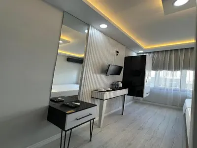 a room with a mirror and a desk and a television at Asıl Kosova Hotel in Istanbul