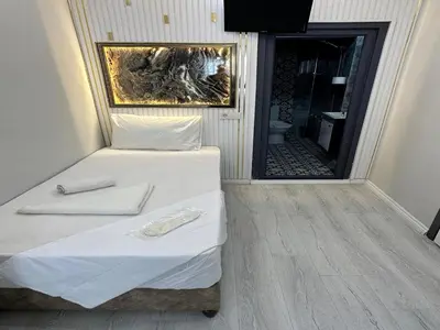 a small room with a bed and a bathroom at Asıl Kosova Hotel in Istanbul