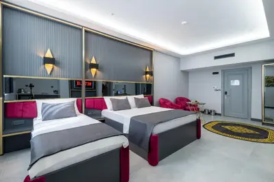 a bedroom with two beds and a red chair at 216 Prestige Hotel in Istanbul