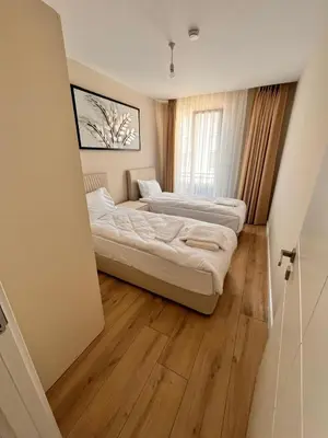 two beds in a room with wooden floors at Sense Suite Residence-KAPALI in Istanbul