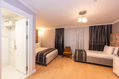 a hotel room with two beds and a chair at The Now Hotel in Istanbul
