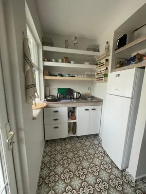 a kitchen with a white refrigerator and a tile floor at BOHO HOUSE Istanbul in Istanbul