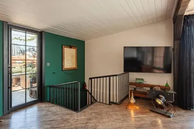 a living room with a flat screen tv on the wall at Panoramic Sea View Loft with Terrace BBQ in Istanbul