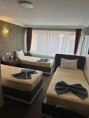 a hotel room with two beds with bow ties on them at Hotel Metropol 1 in Istanbul