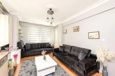 a living room with a black leather couch at Qbra House in Istanbul