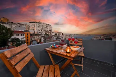 a table and chairs on a balcony with wine glasses at The Maiden Tower From Your Bedroom Romantic View, In Taksim Square in Istanbul