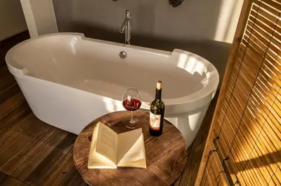 a bath tub with a bottle of wine and a book at Ansen Hotel and Suites in Istanbul