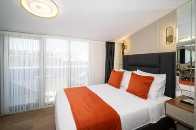 a hotel room with a large bed with orange pillows at Robin Hotel in Istanbul